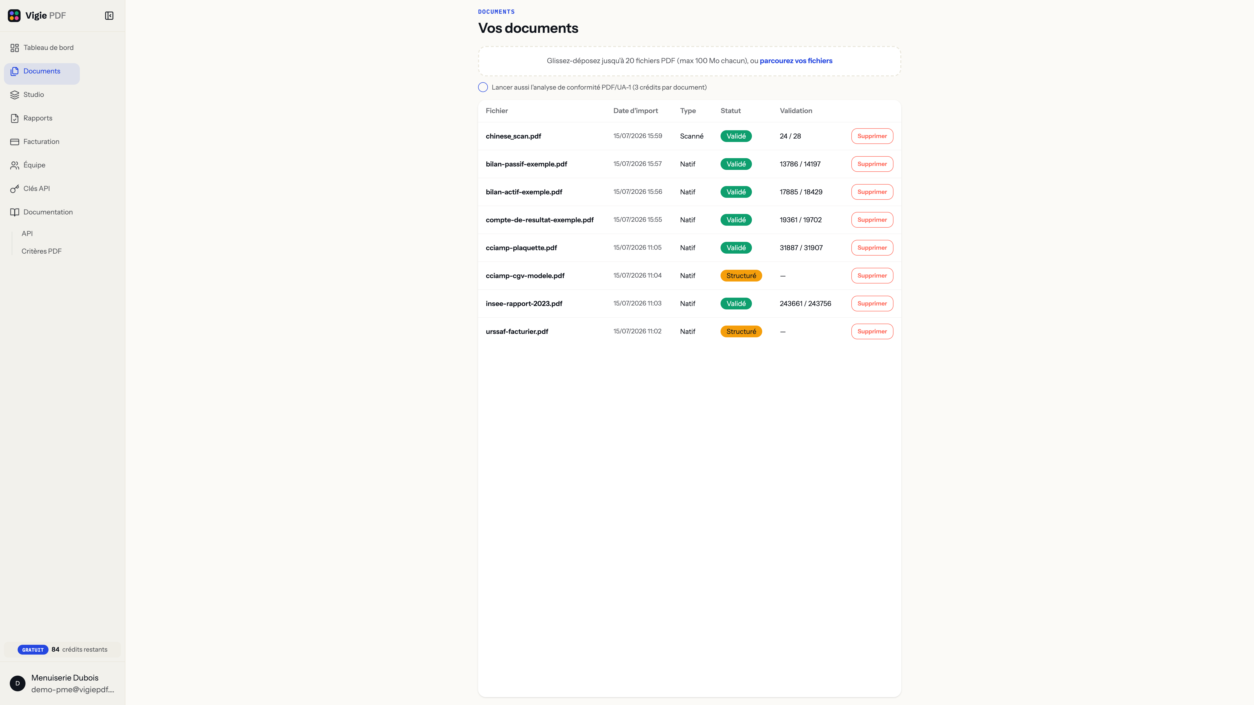 Vue détaillée de la liste des documents dans Vigie PDF : colonnes Fichier, Date d’import, Type, Statut et Validation pour les huit PDF de Menuiserie Dubois — des scores de validation PDF/UA-1 qui vont de 24/28 sur un document scanné à plus de 243 000/243 756 sur un rapport, selon la taille réelle de chaque document